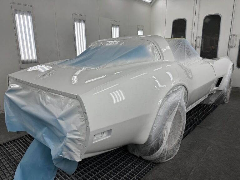 Classic car being prepped and painted in a professional auto restoration shop.