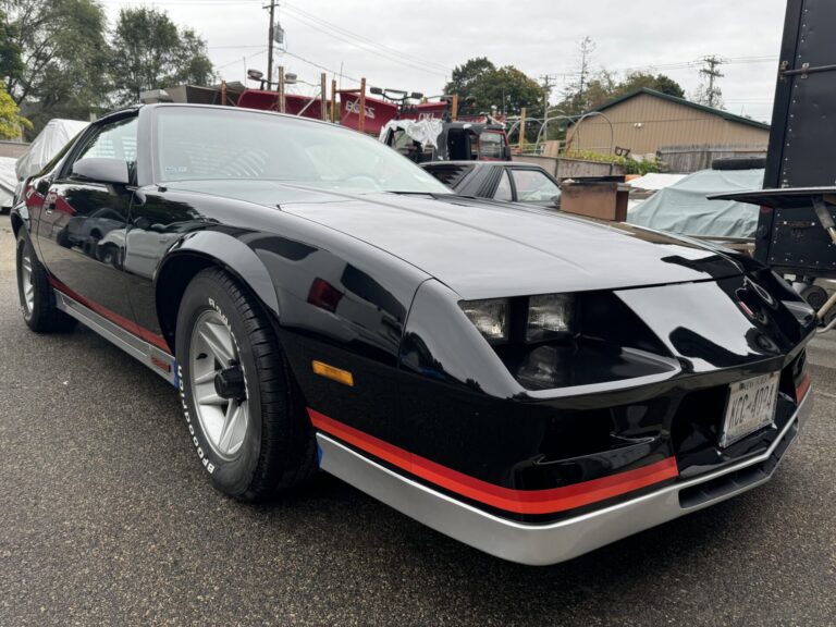 Classic black Corvette sports car at John's Automotive repair shop.