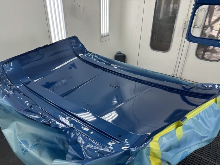 Custom blue car hood freshly painted at John's Automotive.