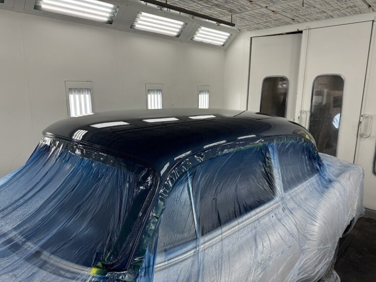 Classic car being painted at John's Auto Restoration workshop.