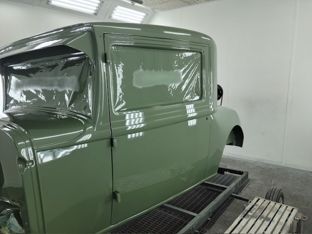 Vintage green truck undergoing restoration at John's Auto Restorations facility.