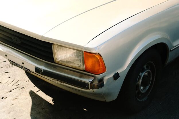 Close-up of a damaged car frame showing rust and structural issues.