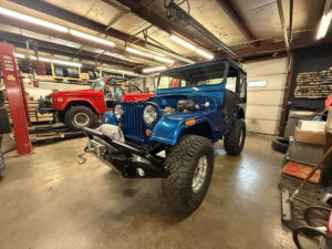 Blue vintage Jeep undergoing restoration at John's Auto Restorations.