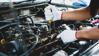 Technician repairing car engine at Kabayan Auto Repair LTD.