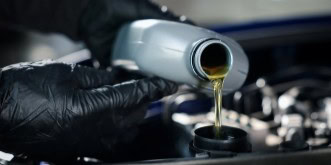 Technician pouring engine oil during vehicle maintenance at Kabayan Auto Repair.