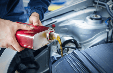 Professional oil change being performed on a vehicle engine.