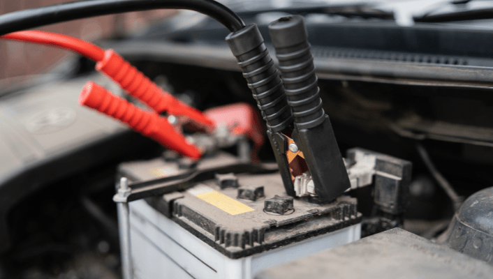 Car battery with jumper cables for jump start service.