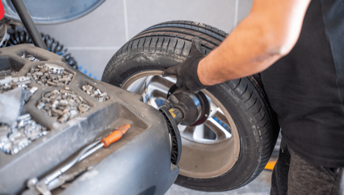 Technician performing tire alignment on a vehicle at Kerrigan's Automotive.