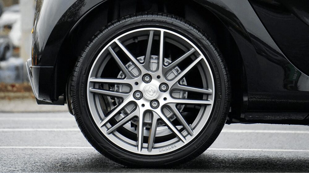 Close-up of a car wheel showing misalignment issues and importance of proper wheel alignment.