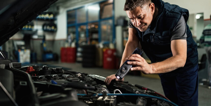 Auto repair technician inspecting engine at Kerrigan's Automotive in Petersburg, IL.