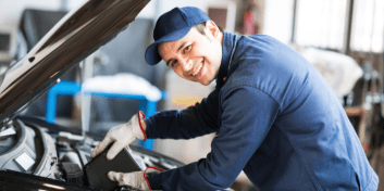 Skilled automotive technician working on a car engine at Kevin and Kayla's Automotive.