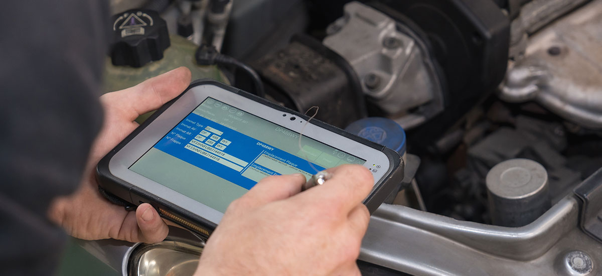 Mechanic inspecting car engine performance for winter readiness
