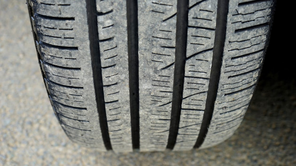 Close-up of a car tire showing minor damage and tread pattern for repair tips.