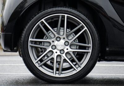 Close-up of a car tire with minor damage on the road.