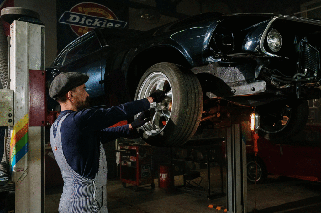 Mechanic replacing a car tire on a lift at K Tire Pro auto shop.