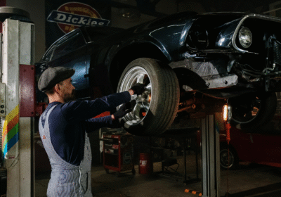 Mechanic replacing a car tire on a lift at K Tire Pro auto shop.