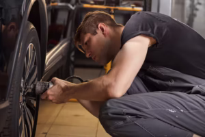 concentrated-professional-auto-mechanic-man-repairs-wheel-that-has-broken