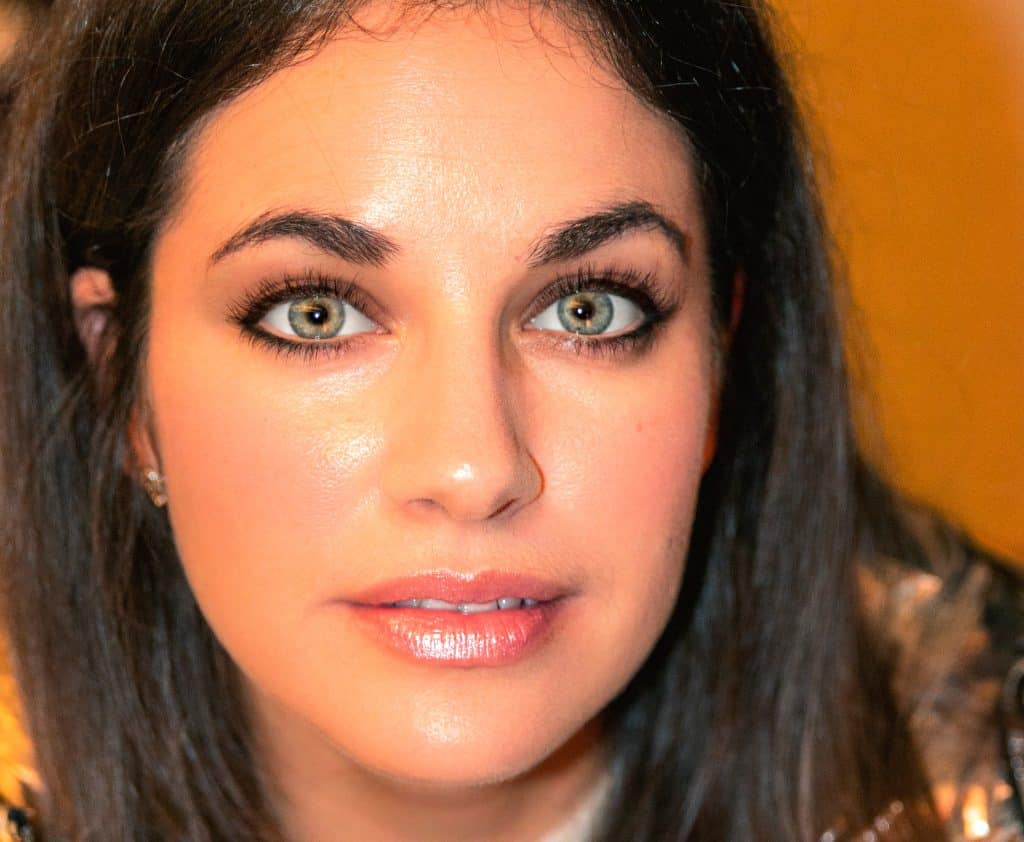 Brillante retrato de mujer con ojos azules y piel radiante, resaltando belleza natural y cuidado facial, ideal para contenido de belleza y bienestar.