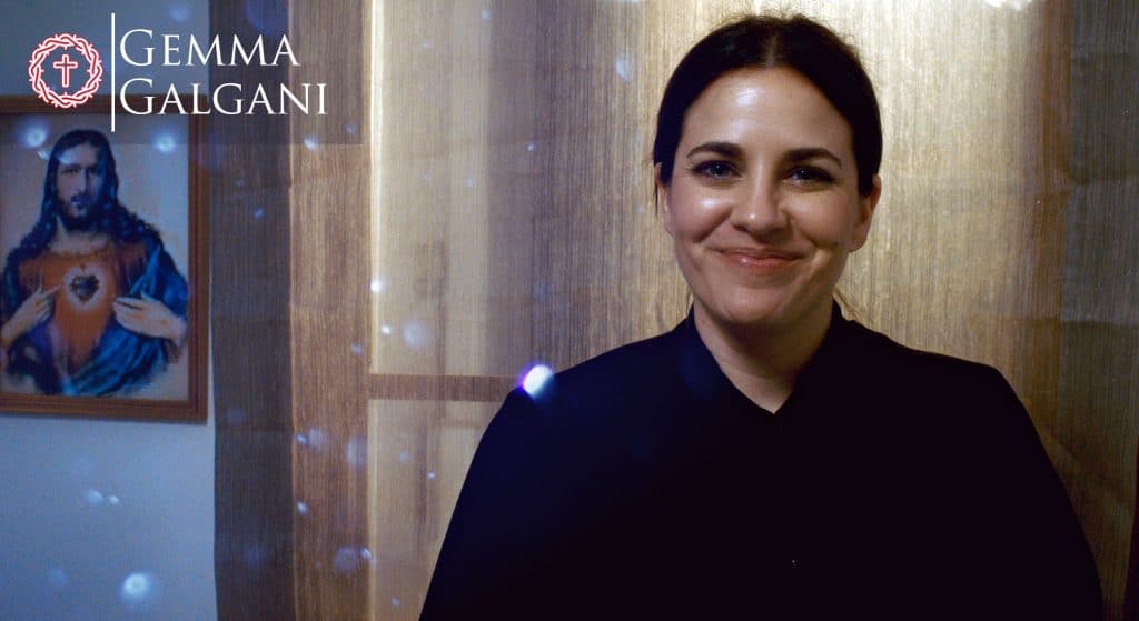 Consoladora mujer con sonrisa en ambiente religioso y espiritual, imagen de fe y devoción, fondo con pintura de Jesús y ambiente cálido, representando inspiración y esperanza financiera, personal y espiritual.