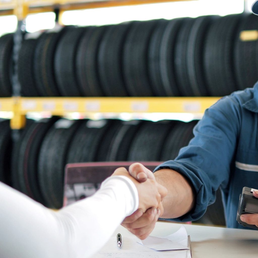 Friendly handshake at tire shop for auto repair and tire services.