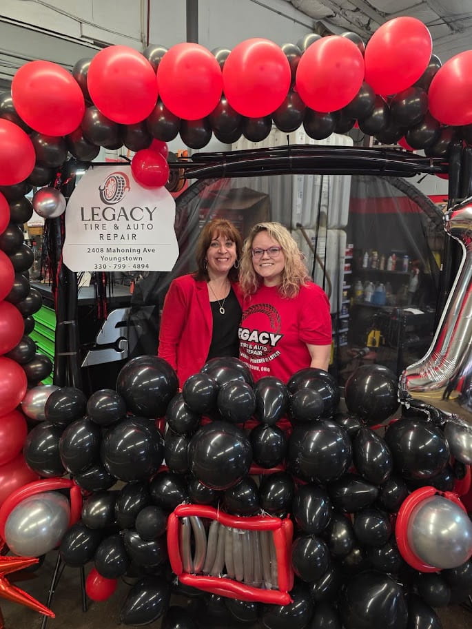 Auto repair shop with festive balloon display featuring red, black, and silver balloons.