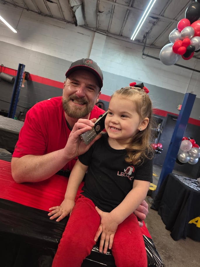 Happy customer and technician at Legacy Tire & Auto Repair, providing expert auto services.