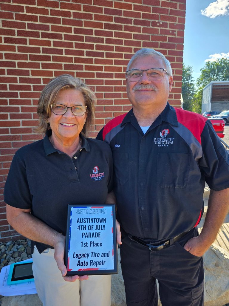 Two team members from Legacy Tire & Auto Repair at Austintown 4th of July Parade.