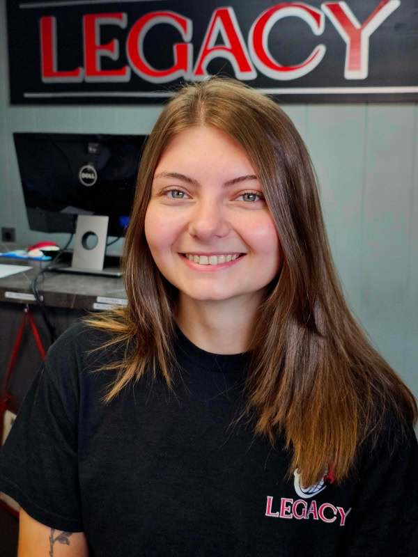 Smiling woman at Legacy Tire & Auto Repair shop.