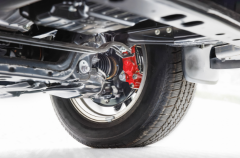 Vehicle underside showing brake components and suspension system.