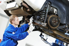 Technician inspecting car suspension during routine maintenance.