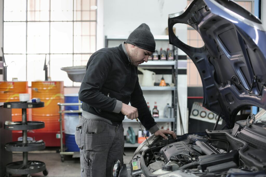 Skilled mechanic inspecting car brakes in auto repair shop.