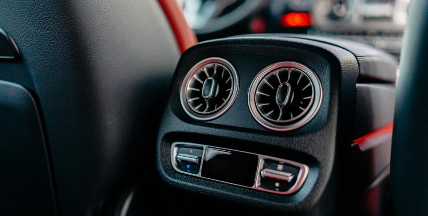 Close-up of car A/C vents showing airflow controls and vents.