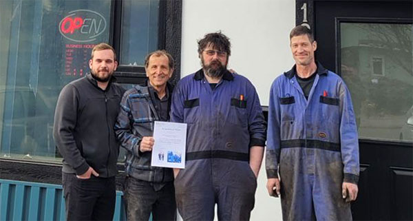 Auto repair team standing outside L Stop Auto shop in Vancouver, ready to service your vehicle.