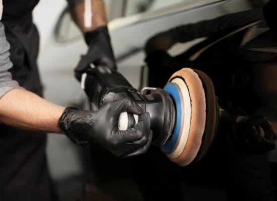 Car polishing with buffer for a shiny, clean vehicle finish.