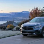 Sleek gray SUV parked outside with mountain and lake background.