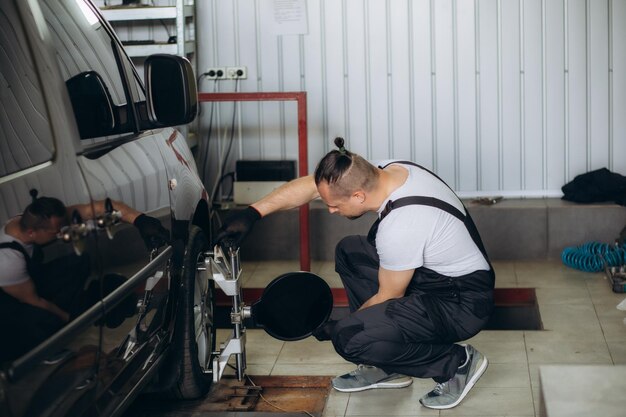 Technician checking tire pressure and condition on a vehicle at Macy's Tire & Lube.