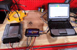 Automotive diagnostic tools connected to a laptop for vehicle testing at MADA Autosport Inc.