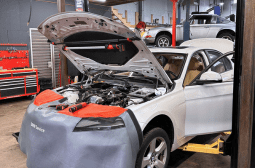 Car undergoing repair at MADA Autosport Inc. workshop.