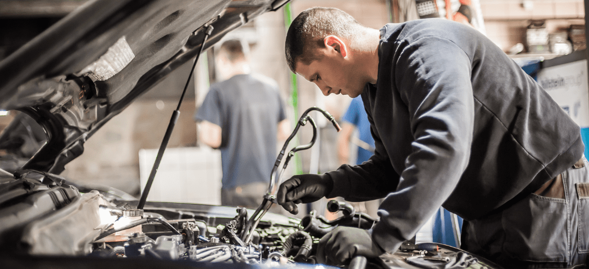 Technician repairing a BMW engine at MADA Autosport Inc.