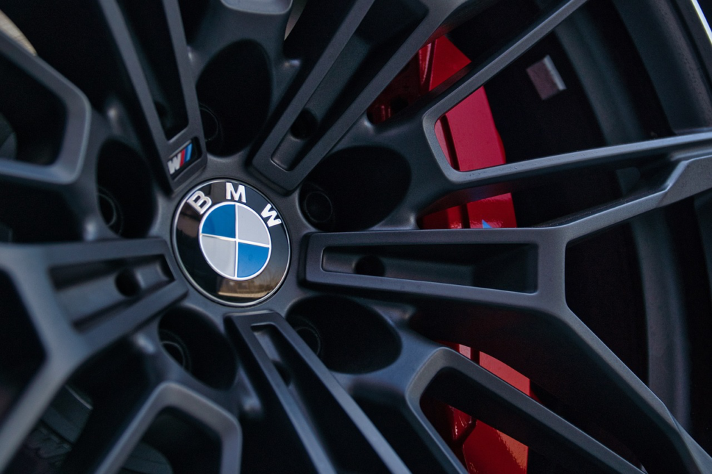 Close-up of a BMW wheel and red brake caliper during electrical diagnosis.