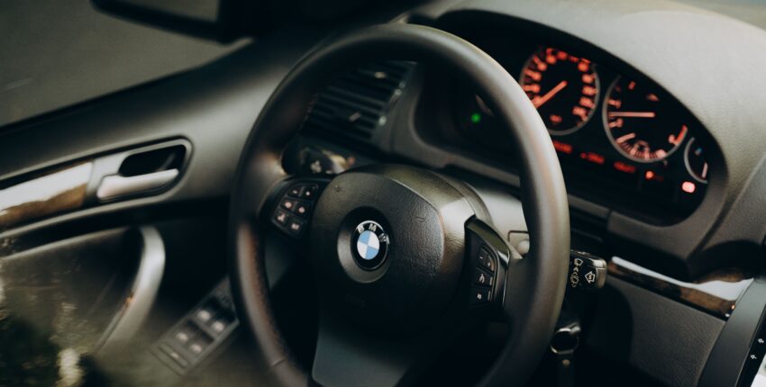 Close-up of BMW steering wheel and dashboard interior.