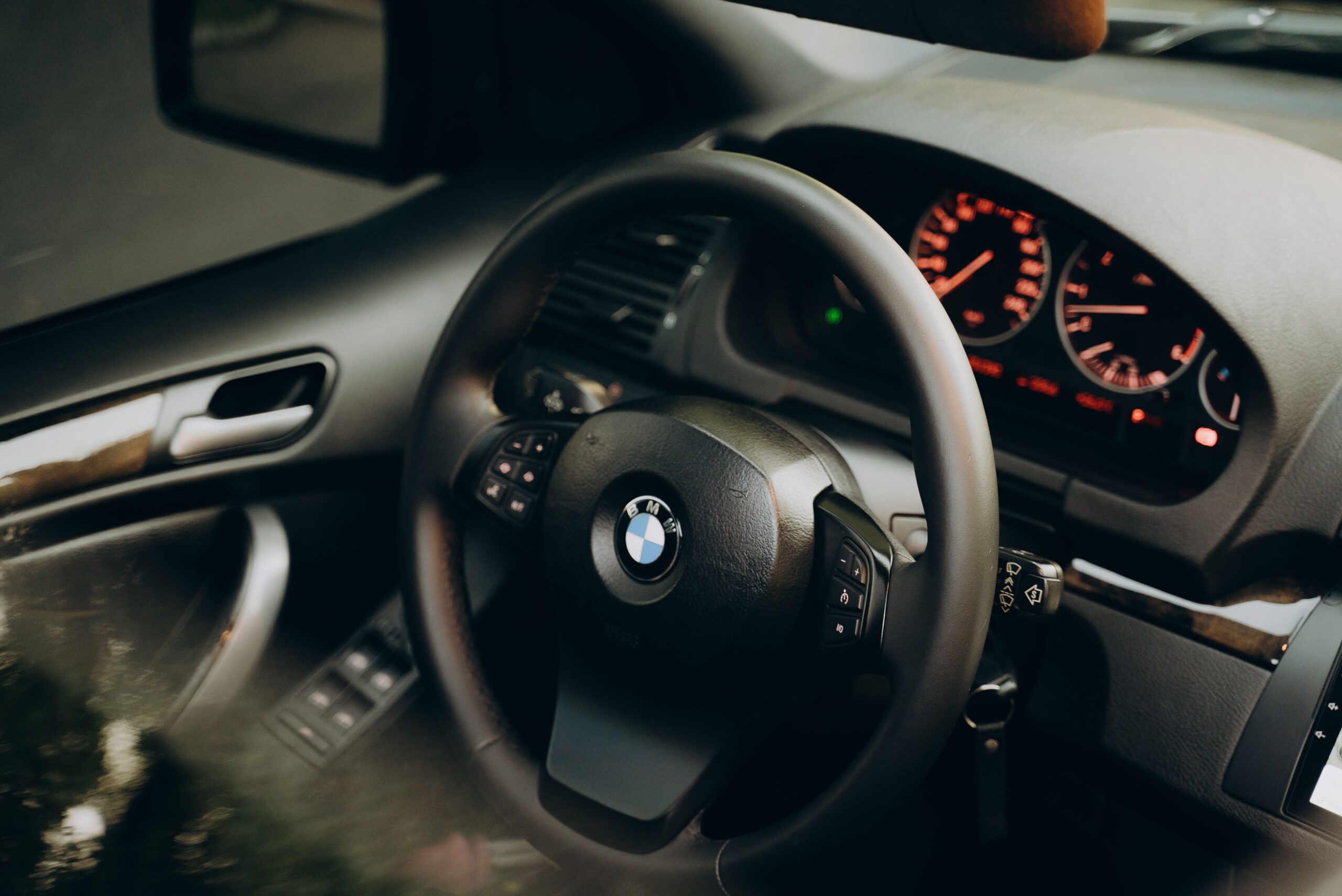 Close-up of BMW steering wheel and dashboard interior.