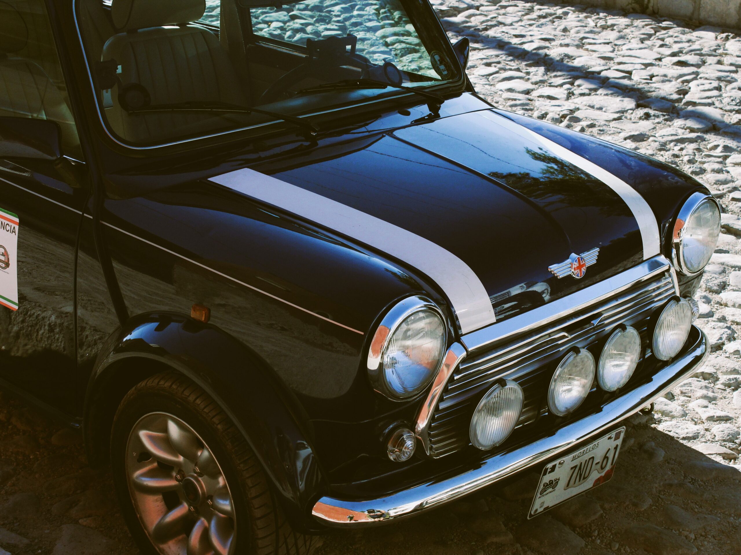 Vintage Mini Cooper with rally lights on snowy road in Vancouver.