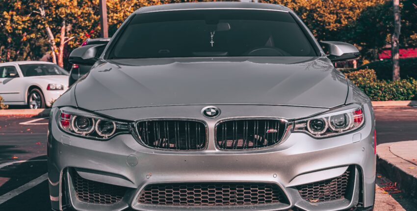 Close-up of a silver BMW M4 sports car in a parking lot.