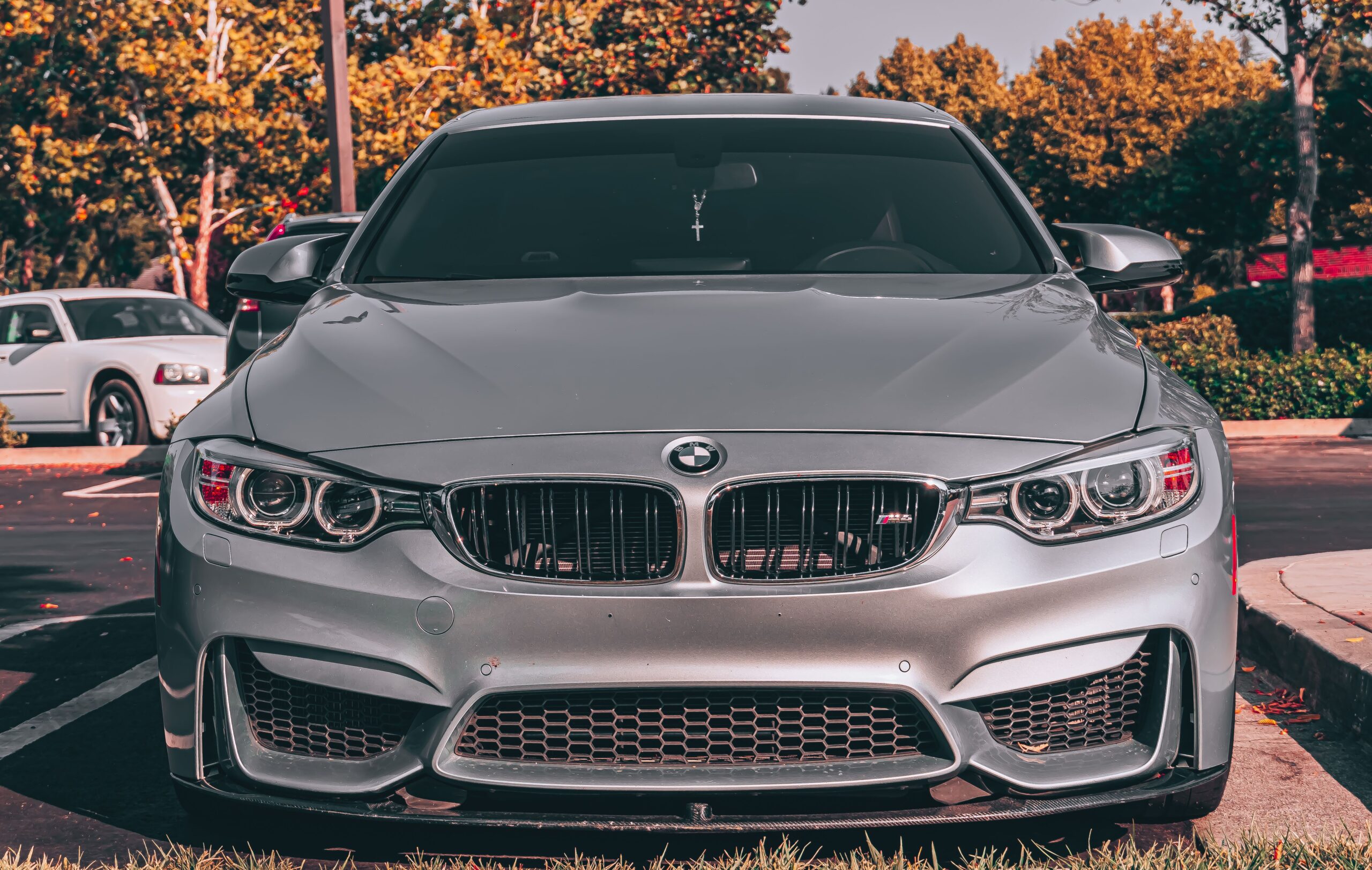 Close-up of a silver BMW M4 sports car in a parking lot.