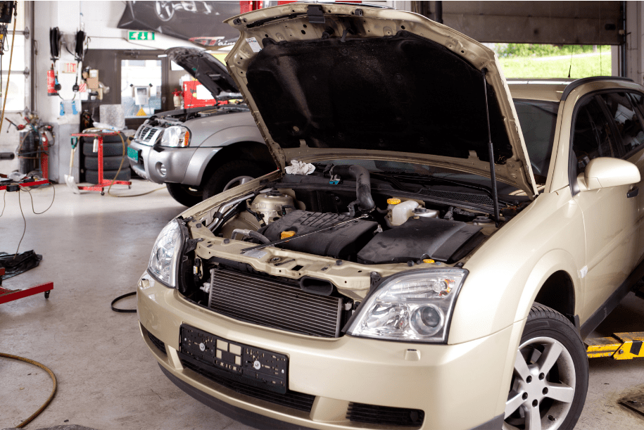 Car engine under maintenance at Masonic Smog & Repair shop.