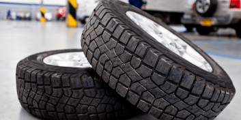 Close-up of two tires stacked, highlighting tire replacement services.