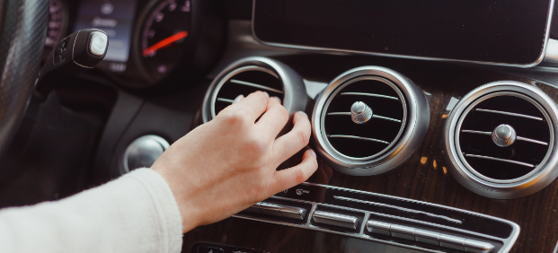 Close-up of a person adjusting a car air vent, showcasing vehicle interior maintenance.