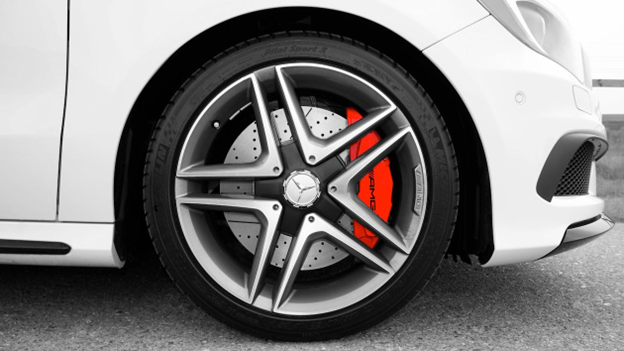 Close-up of a sporty car wheel with red brake caliper and alloy rim.