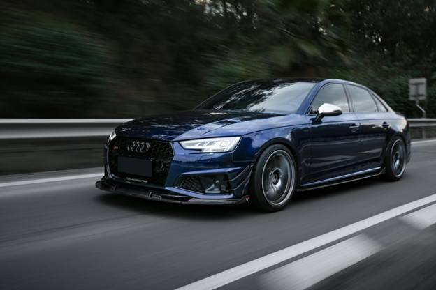Modern blue Audi sedan driving on the highway, showcasing vehicle maintenance.